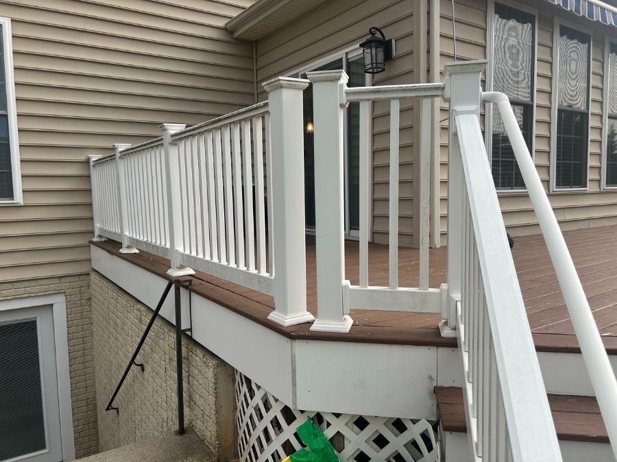 Composite deck with white railings on tan home