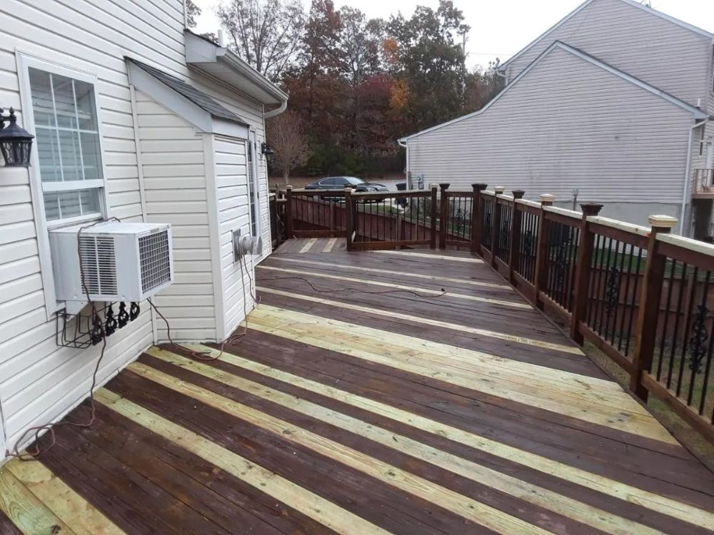 Weathered deck with mixed stained and bare boards before refinishing